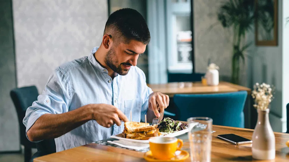 A man in a restaurant eats alone
