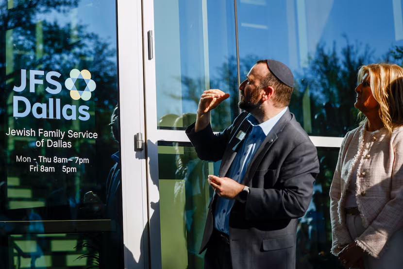 Rabbi Mordechai Harris places a mezuzah at the entrance to the new Jewish Family Service...