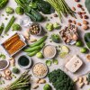 This photo shows a variety of plant-based protein sources - legumes, nuts, grains and vegetables - photographed from above.