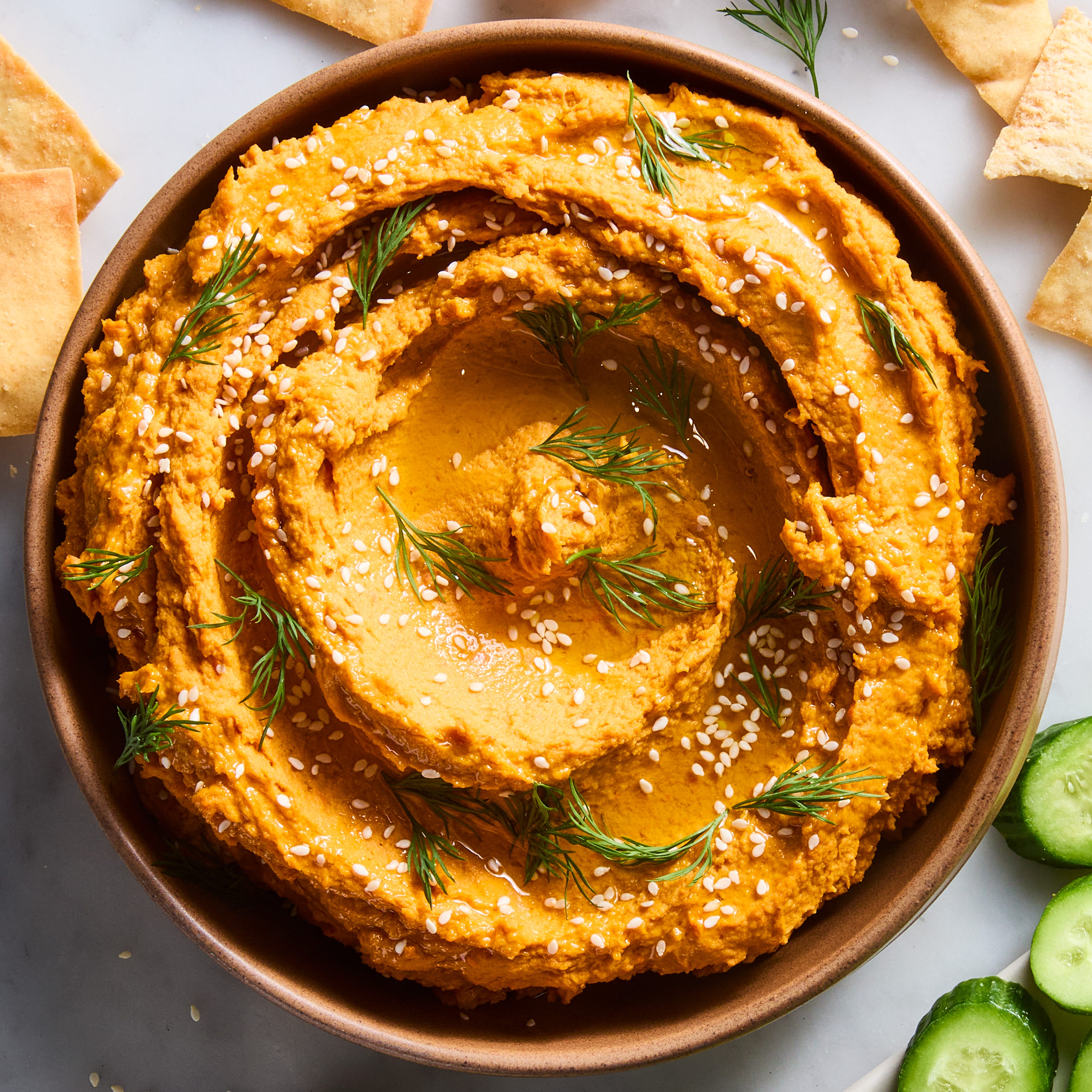 Carrot hummus carrot hummus in a bowl with cucumber and pita chips