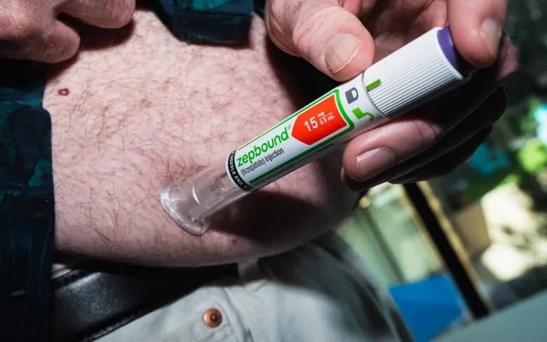 A man lifts his shirt for a Zepbound injection.