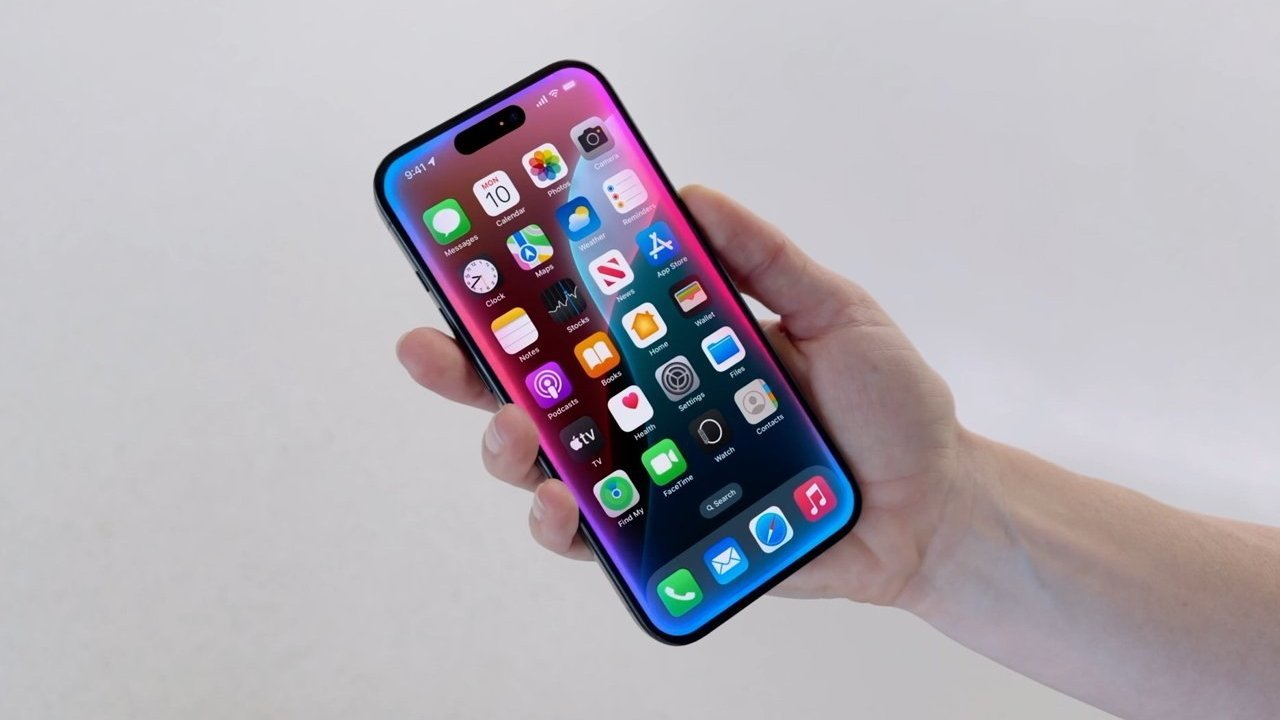 Holding a modern smartphone with a colorful screen displaying multiple app icons on a simple light background