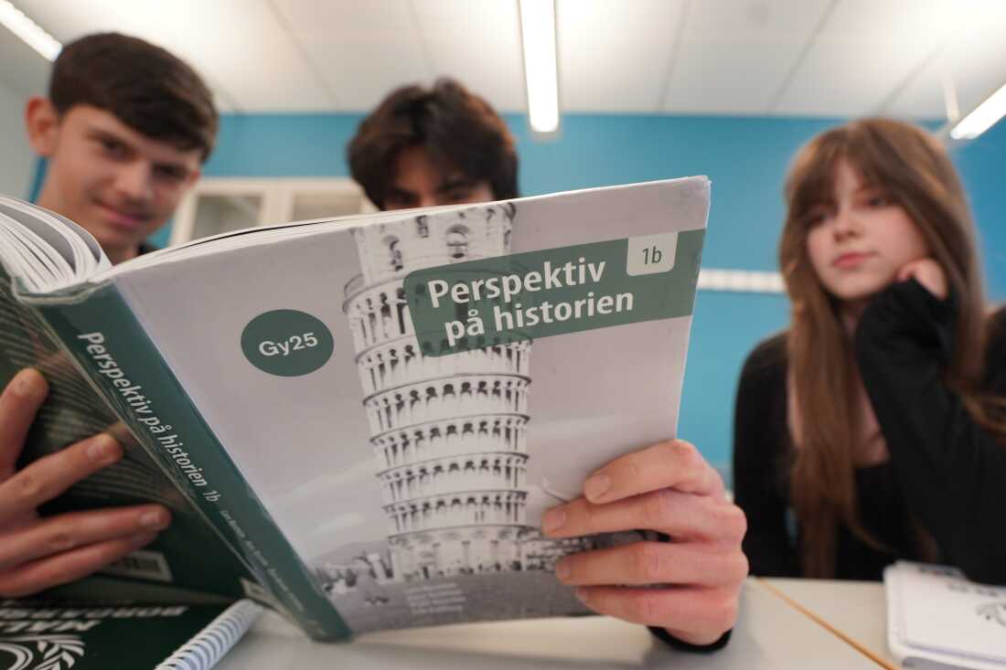 High school students Vasilije Stjepanovic, Aslan Ocean Kilikasson and Melina Sallahi, from left, pose with a history textbook at Malmo Borgerskola High School in Malmo, Sweden, on May 21, 2026.